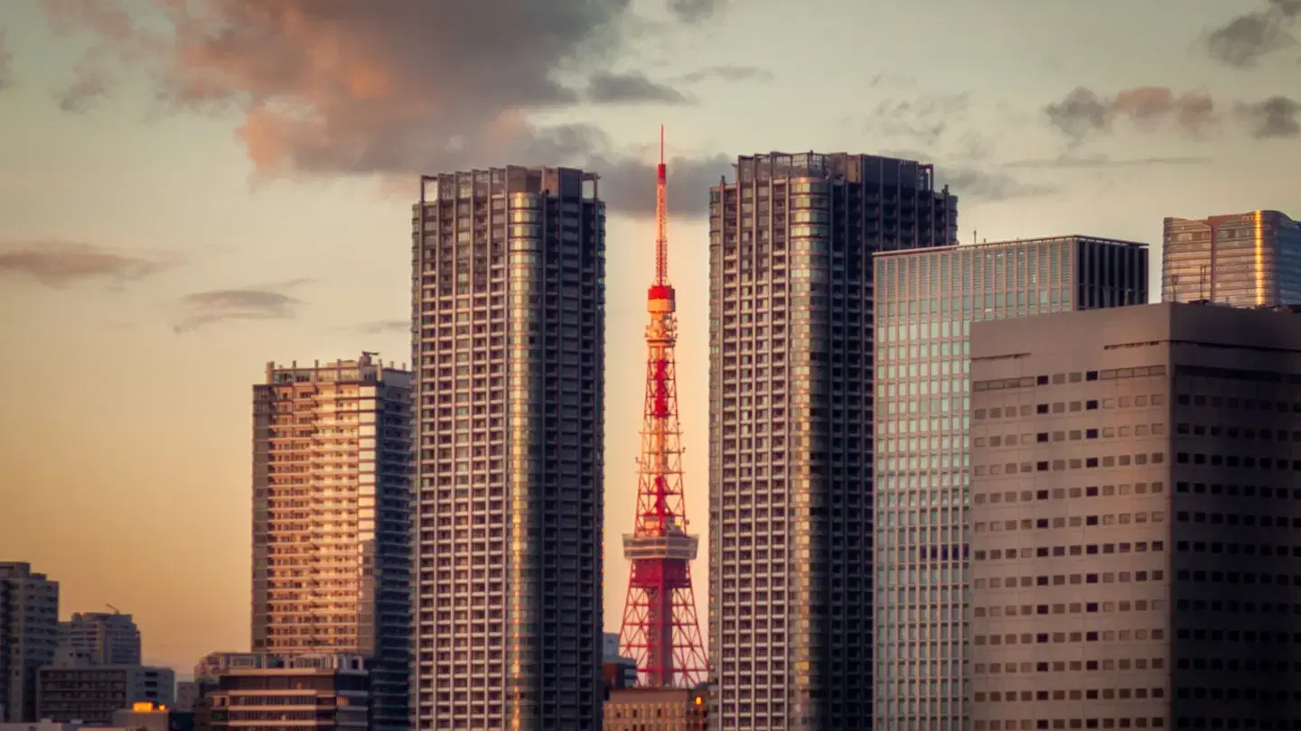 Tokyo Tower framed by modern skyscrapers at sunset